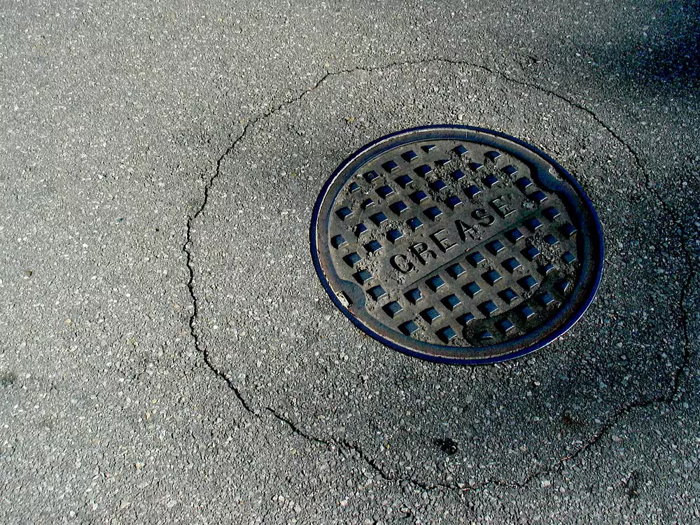 A commercial grease trap opened for cleaning