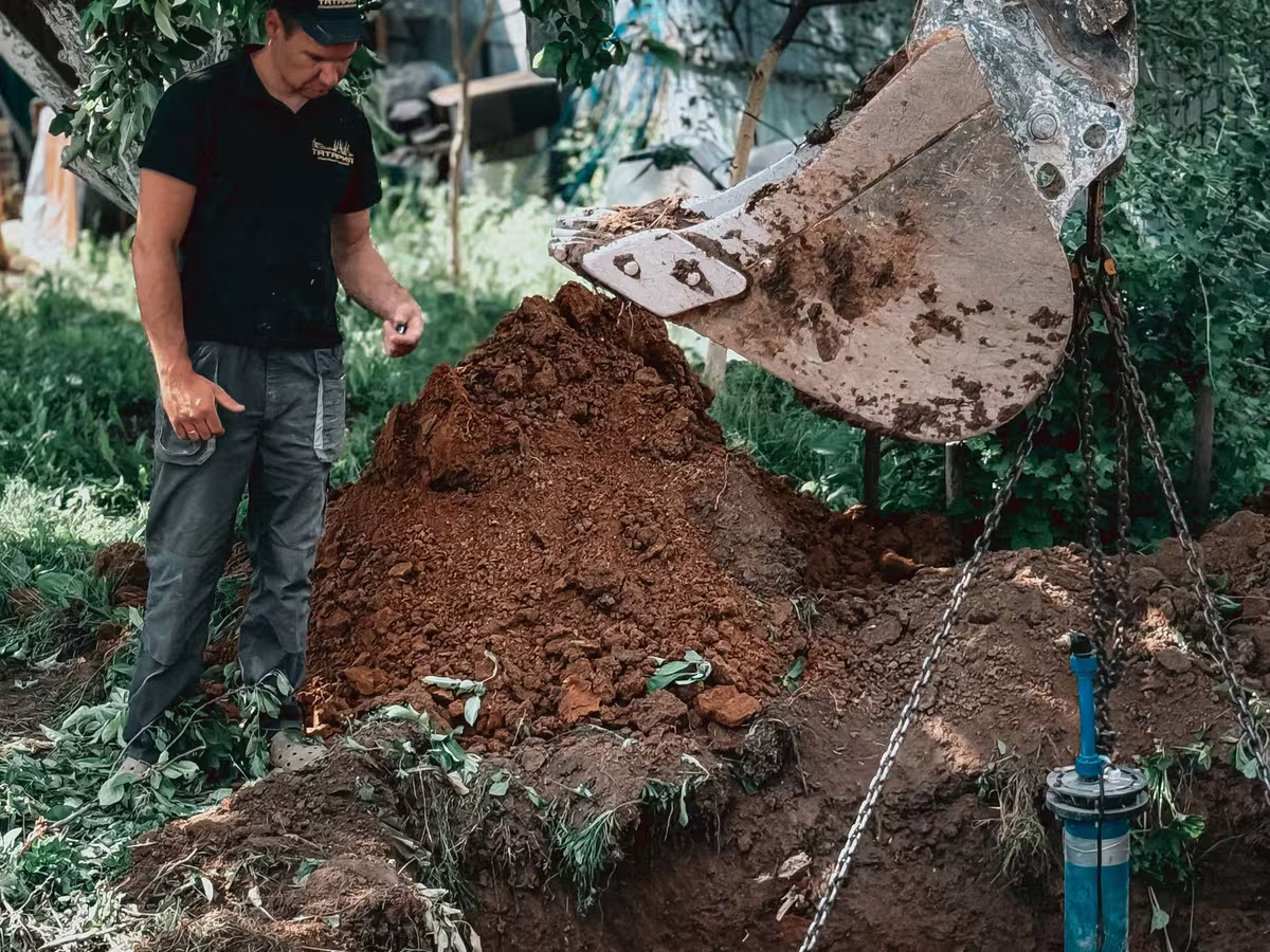 A technician looking into an opened septic chamber